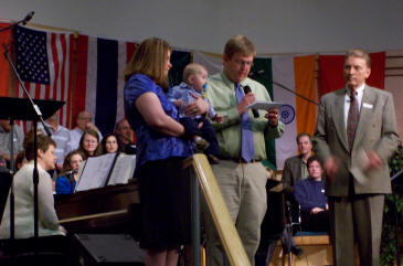 Andy reading Stephan's dedication statement in church.  Pastor Jerry is looking on.